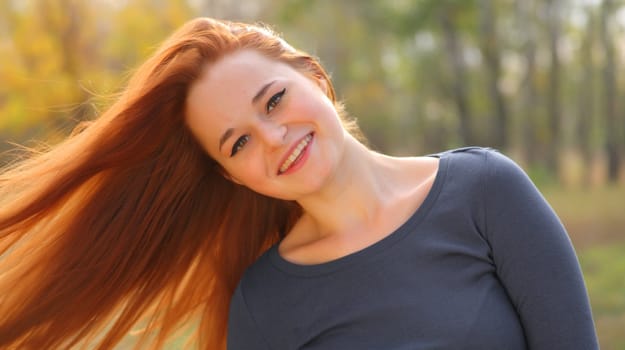 Young redhead woman in the park having fun