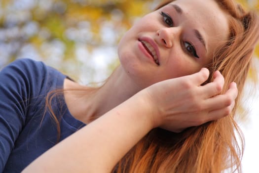 Portrait of a beautiful redhead girl smiling outdoors