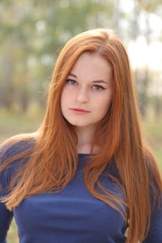 Natural beautiful red-haired girl head and shoulders shot outdoor
