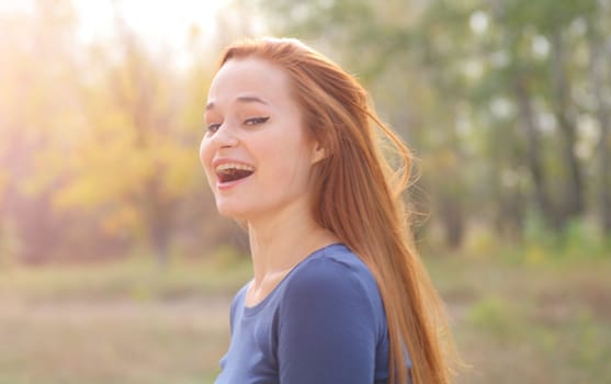 Young redhead woman in the park having fun