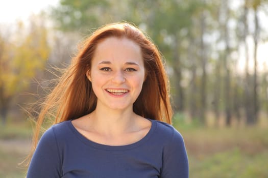 Young redhead woman in the park having fun