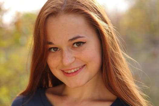 Young redhead woman in the park having fun