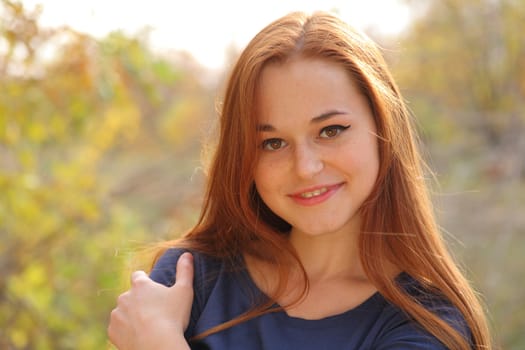 Young redhead woman in the park having fun