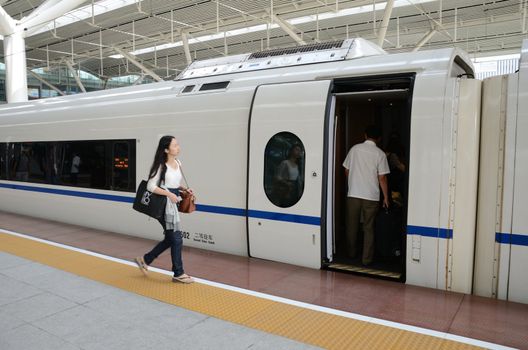 SHENZHEN, CHINA - SEPTEMBER 9:  Unidentified girl boards fast train on September 9, 2012. With speed 300km/h train arrives Wuhan within 5 hours.