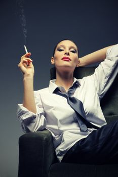 Sensual woman smoking a cigarette, fashion model portrait