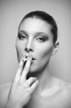 Portrait of beautiful young woman smoking a cigarette