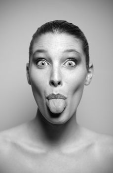 Young beautiful woman pokes out her tongue