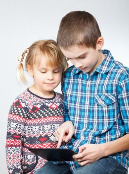 Boy shows little sister how to use a touch pad