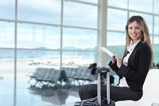 Businesswoman using tablet computer at departure lounge