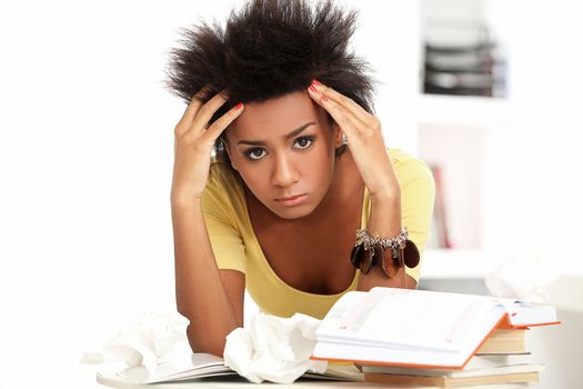 Young black woman tired from studying with books