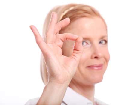 Beautiful mid aged woman showing ok gesture on a white background