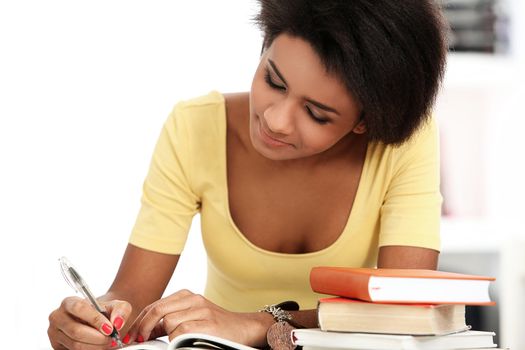 Young and beautiful afro woman studying with books