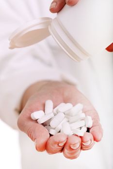 Close up of doc hand holding pills isolated on a white