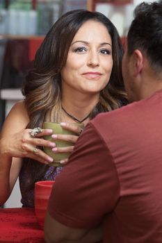 Confident mature Latino woman with man at table