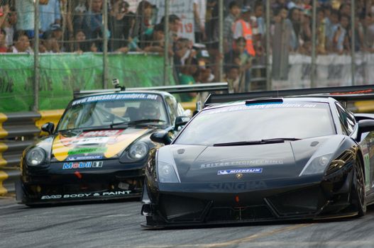 BANG SAEN - DECEMBER 22: Cars 28 and 18, the Lamborghini Gallardo of Chonsawat Aswane and the Porsche GT2 of Wutikon Intrapusak, racing during the 2012 Bang Saen Speed Festival in Thailand on December 22, 2012.