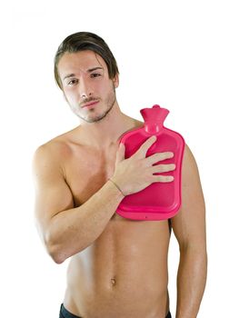 Muscular guy with shoulder ache, holding hot water bottle to relieve pain