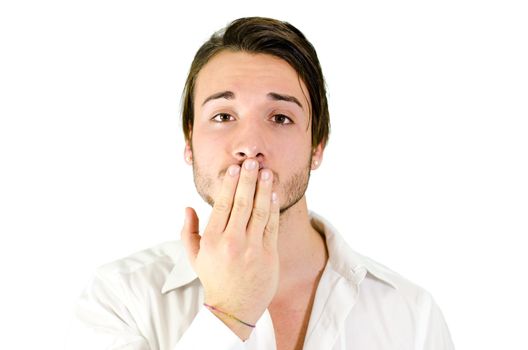 Young man covering mouth with hand, should not speak, be silent