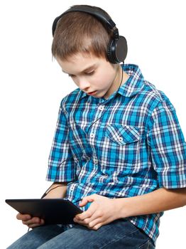 Portrait of 10 years boy wearing headphones using a touch pad