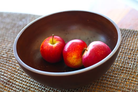Red apple in wood bowl