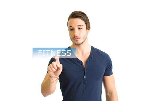Fit and muscular young man clicking the word fitness on virtual button