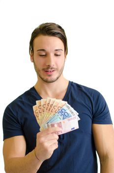 Successful and happy young man with euro bills (banknotes) in his hands