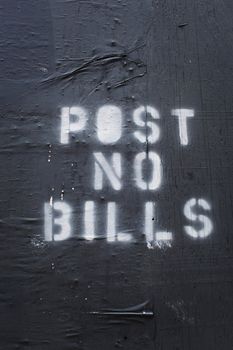 Words "Post No Bills" sprayed on an old wall.