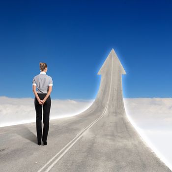 Concept of the road to success with a businesswoman standing on the road