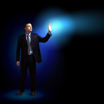 Young successful businessman holding a shining light in his hand as a symbol of success and advancement.