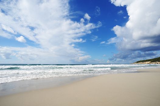 Landscape with sea and sand, white clouds in the sky