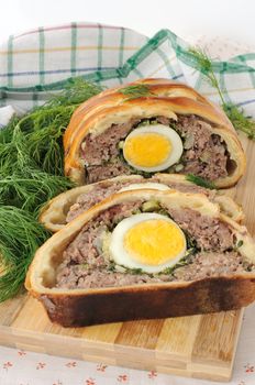 Sliced meatloaf with egg and herbs baked in pastry