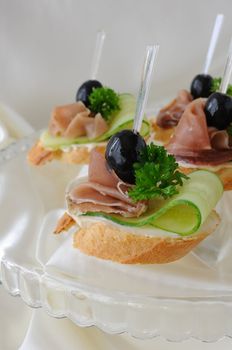 Mini sandwiches with ham and cucumber on a baguette