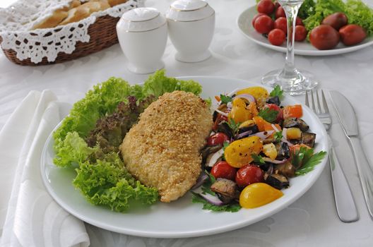 Chicken schnitzel with sesame with eggplant, tomato and pepper