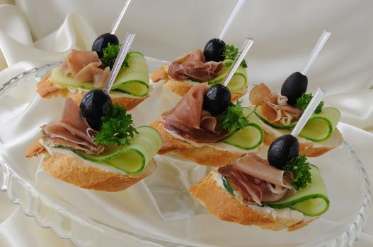 Mini sandwiches with ham and cucumber on a baguette