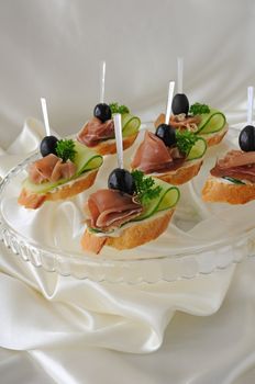 Mini sandwiches with ham and cucumber on a baguette