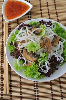 Salad of rice noodles in lettuce leaves with mushrooms in breadcrumbs