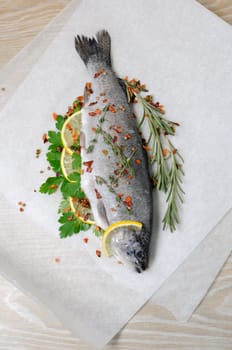 Fresh trout with lemon and spices on paper
