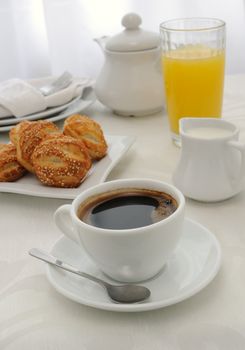 Morning cup of coffee with freshly baked rolls with sesame seeds, juice and milk