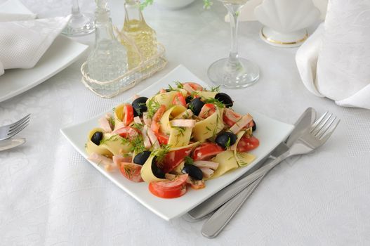 Pasta salad with ham, tomato and olive sauce