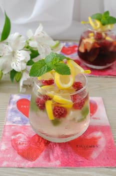 A glass of fresh homemade lemonade with mint and raspberries