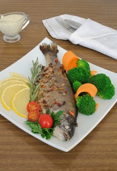 Baked sea bass in spices with broccoli and carrots
