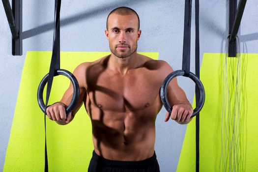 Crossfit dip ring man relaxed after workout at gym dipping exercise