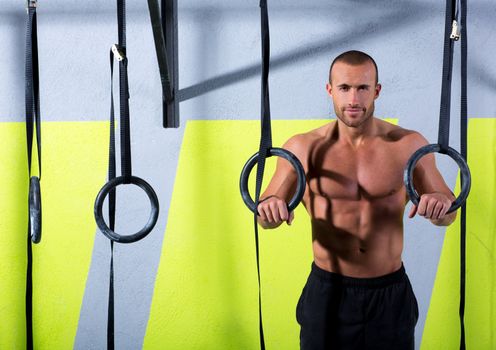 Crossfit dip ring man relaxed after workout at gym dipping exercise