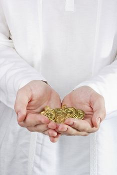 Close-up photograph of man's hands holding golden coins.