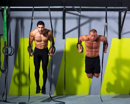 Crossfit dip ring two men workout at gym dipping exercise