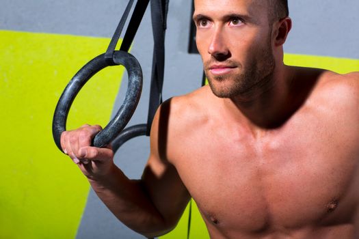 Crossfit dip ring man relaxed after workout at gym dipping exercise