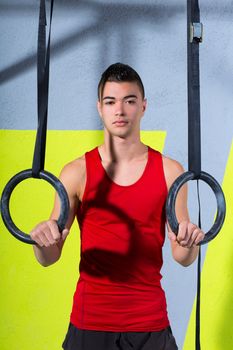 Crossfit dip ring young man relaxed after workout at gym dipping exercise