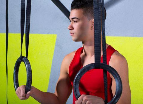 Crossfit dip ring young man relaxed after workout at gym dipping exercise