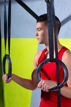 Crossfit dip ring young man relaxed after workout at gym dipping exercise