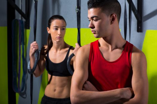 Crossfit dip ring man and woman relaxed after workout at gym dipping exercise