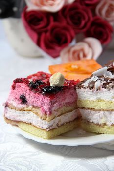 Two pieces of tasty cake and bouquet of roses